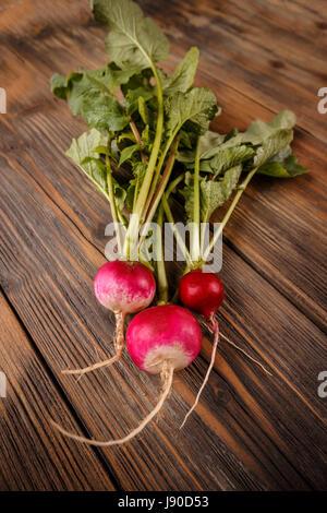 Freshly harvested radishes with leaves on old wooden surface Stock Photo