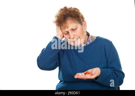 Picture of a senior woman having a headache, holding her pills Stock Photo