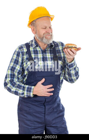 Picture of a hungry mechanic having a lunch break, eating hamburger Stock Photo