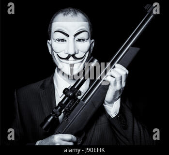 MILAN,ITALY, May 2017: Businessman wear anonymus mask and hold sniper rifle.Editorial photo. Stock Photo