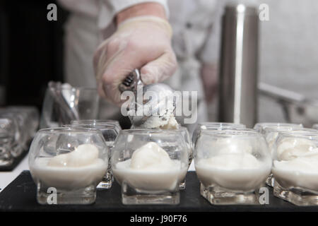 Scooping ice cream into glass, catering