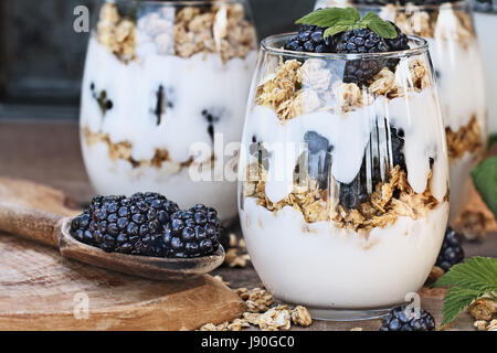 Blackberry parfaits made with Greek yogurt, granola and fresh blackberries. Extreme shallow depth of field with selective focus on parfait in foregrou