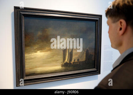 Cologne, Germany. 31st May, 2017. A man stands in front of the painting 'Dordrecht harbor in the moonlight' by Albert Cuyp in Cologne, Germany, 31 May 2017. The exhibition 'Between bright and cloudy - Natural wonders in lower saxon painting' can be seen in the Wallraf Richartz Museum between 01 June 2017 and 04 February 2018. Photo: Oliver Berg/dpa/Alamy Live News Stock Photo