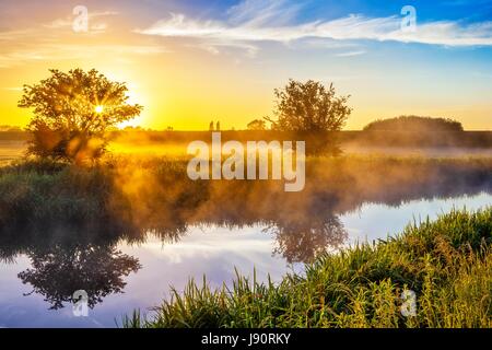 Burscough, Lancashire, 31st May 2017. UK Weather. A beautiful start to the day as the sunrise lights the mist rising from the famous Leeds to Liverpool Canal at Burscough in West lancashire. Quite a cool morning will soon see temperatures rising to the mid 20's as the fabulous warm summer weather returns after a few days of rain over this picturesque part of northern England. Credit: Cernan Elias/Alamy Live News Stock Photo