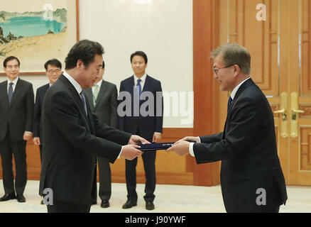Seoul, South Korea. 31st May, 2017. South Korea's President Moon Jae-in (R) presents the appointment book to new Prime Minister Lee Nak-yon in Seoul, South Korea, May 31, 2017. South Korea's parliament on Wednesday approved the nomination of Lee Nak-yon as the prime minister. Credit: Blue House/Xinhua/Alamy Live News Stock Photo
