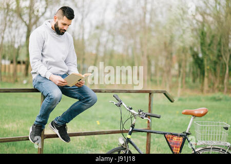 Handsome bearded man learning in park concept Stock Photo