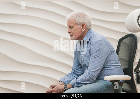 senior man sitting in luxury office chair Stock Photo