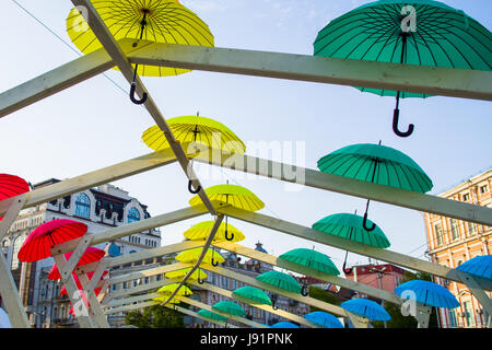 Brightly coloured floating umbrellas fill the sky Stock Photo