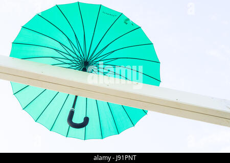 Brightly coloured floating umbrellas fill the sky Stock Photo