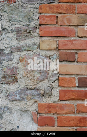 Stone wall background closeup, vertical plastered grunge red brick stonewall, beige limestone pattern, old aged weathered beige lime plaster texture,  Stock Photo