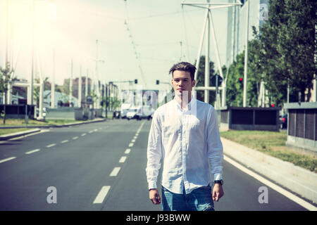Attractive smiling man standing in the middle of city street Stock Photo