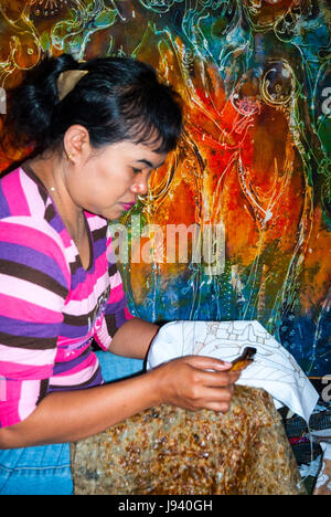 YOGYAKARTA, INDONESIA - SEPTEMBER, 13: Indonesian woman applying wax on batik in workshop. Batik is traditional art made by applying wax and dye on fa Stock Photo