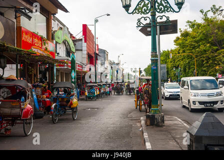 YOGYAKARTA, INDONESIA - SEPTEMBER, 13: Main street in Yogjakrata full of local traffic - horses, rickshaws, carriages, motorbikes and cars in Yogyakar Stock Photo
