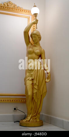 Golden Statue of Woman with Lamp in hand Stock Photo
