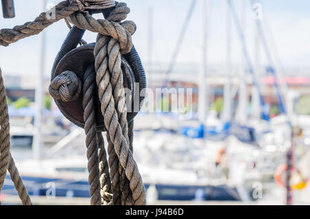 Rigging on the old sailboat against the background of modern yachts Stock Photo