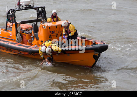 Westminster, London, UK. 5th June, 2017. RNLI crew from the Tower Lifeboat station pull a woman from the River Thames by Westminster Bridge by the Houses of Parliament. The woman was recovered safely from the water. A passing tourist told police she smoked a cigarette, uttered something and then deliberately jumped. She is the fourth person to have jumped off Westminster Bridge after the terrorist attack there on 22 March 2017. Credit: On Sight Photographic/Alamy Live News Stock Photo