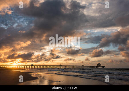 South Carolina, USA. 5th Jun, 2017. Dawn breaks over the Folly Beach Pier on a cloudy morning June 5, 2017 in Folly Beach, South Carolina. Folly Beach is a quirky beach community outside Charleston known to locals as the Edge of America. Credit: Planetpix/Alamy Live News