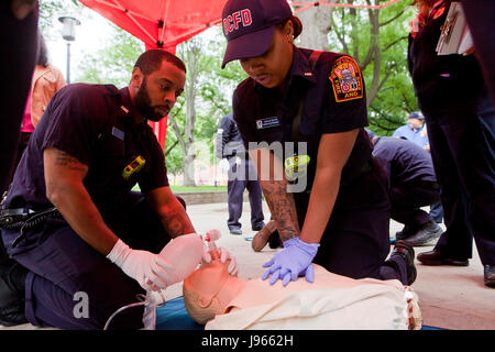 Fire and EMS technicians (EMT, Paramedic) performing CPR on CPR manikin (CPR training) - Washington, DC USA Stock Photo