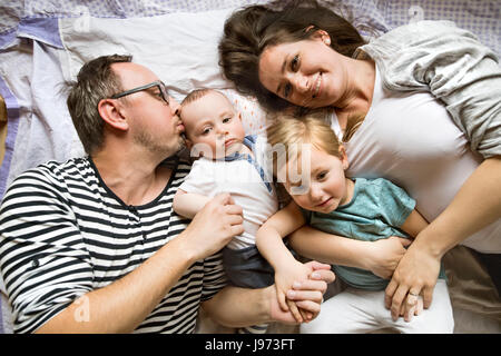 Young family together at home laying on floor. Stock Photo