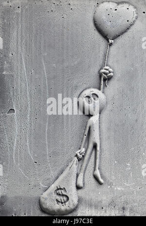 Metal man holding a heart and a sack of dollars, Brick lane London Stock Photo