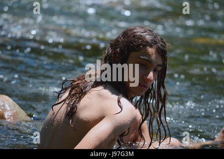 Young teenager enjoys a bath in the Calamuchita River, Cordoba, Argentina Stock Photo