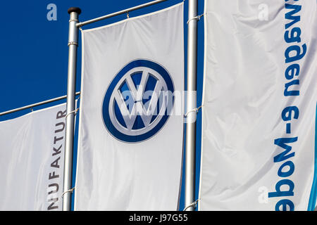 VW logo on the flag in front of Glaeserne Manufaktur, Transparent Factory, Volkswagen Factory, Car Production, Dresden, Saxony, Germany, Europe Stock Photo