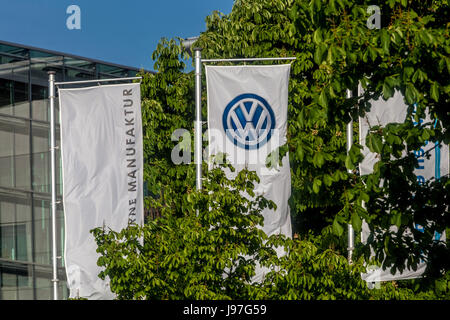 VW logo on the flag in front of Glaeserne Manufaktur, Transparent Factory, Volkswagen Factory, Car Production, Dresden, Saxony, Germany, Europe Stock Photo