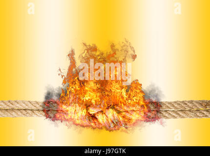 Strong rope with a knot, bursted into flames, isolated against the golden colored background Stock Photo