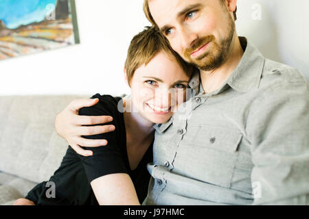 Couple sitting on sofa Stock Photo