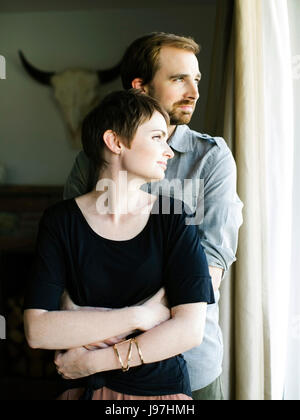 Couple looking through window Stock Photo