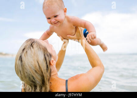 Mother playing with son (12-17 months) in sea Stock Photo