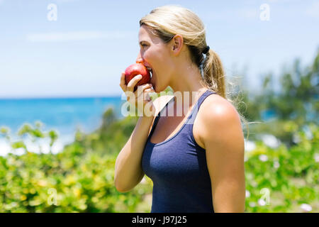 Blonde beautiful woman eating fresh apple Stock Photo