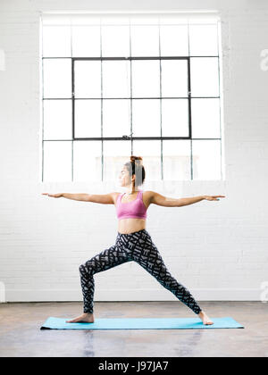 Woman practicing yoga on exercise mat Stock Photo