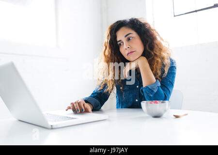 Portrait of mid adult woman using laptop Stock Photo
