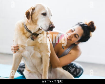 Woman practicing yoga with dog Stock Photo