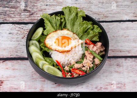 Thai popular food ,Jasmine rice topped stir - fried spicy basil with shrimp ,squid and crispy chicken and fried egg call Kao Pad Kra Prao Kai. Stock Photo