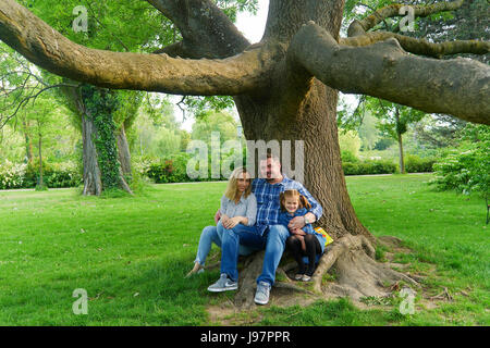 A family sitting under a tree Stock Photo