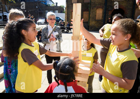 Catherine Apps, from Plaistow, (centre) builds a tower with children from the 13th Forest Gate Rainbows and Brownies group, at the launch of M&S's new Community Transformation Programme, at Stratford Old Town Hall in east London. PRESS ASSOCIATION Photo. Picture date: Thursday June 1st, 2017. The extensive programme will include support for schoolchildren, charities and older people with a target of supporting 1000 communities by 2025. Stock Photo