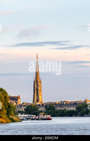 Evening view of Bordeaux waterfront and spire of St Michael's Basilica by the Garonne River, in the wine-growing region of southwestern France Stock Photo
