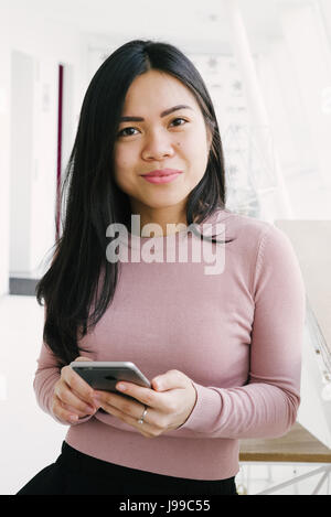 Young asiatic look girl drink green fresh tea and talking to friend on mobile phone Stock Photo