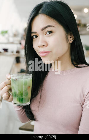 Young asiatic look girl drink green fresh tea and enjoy her life Stock Photo