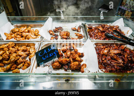 Southern-fried, cajun and chinese hot chicken wings for sale at the hot counter of a supermarket. Stock Photo