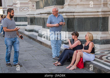 Florence, Italy. 1st June, 2017. A police officer approaches sitting tourists and gets them to move - Plain clothed and uniformed Police clear people off the front steps of the Basillica di Santa Croce, in preparation for cleaning. They ignore the fact that everyone is sitting on the same steps around the corner. The Mayor of Florence institutes a ban on sitting on the steps of major monuments in a bid to clean up the tourist image of Florence. 2017 Credit: Guy Bell/Alamy Live News Stock Photo