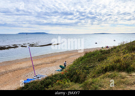 Looking down on the shingle beach from the bluff at Ringstead Bay, Dorset, England, UK, Portland Bill in the distance Stock Photo