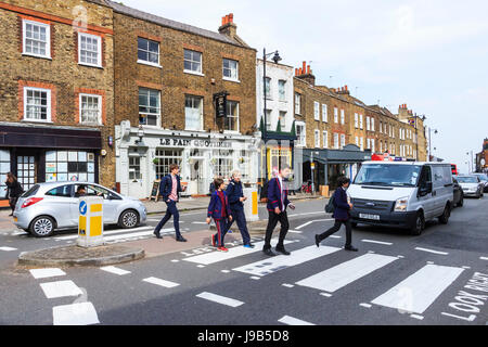 Schoolchildren crossing the road on a zebra pedestrian crossing in Highgate Village, London, UK Stock Photo