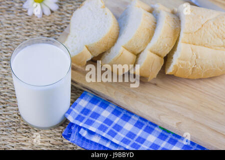 fresh cut long loaf and milk in a jug Stock Photo