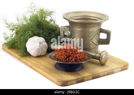 Still Life Spices, Immortin saffron ,marigold staminas in a copper vase on a wooden board on a background of a stern stupa for grinding spices, bunche Stock Photo