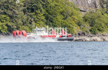 A Canadian Coast Guard hovercraft speeds alongside the shoreline of Ruxton Island, in British Columbia's Gulf Islands. Stock Photo