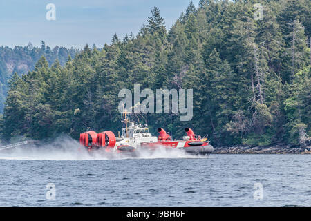 A Canadian Coast Guard hovercraft speeds alongside the shoreline of Ruxton Island, in British Columbia's Gulf Islands. Stock Photo