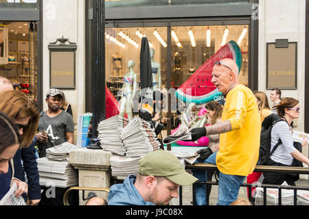 An Evening Standard newspaper vendor at Oxford Circus tube station, London, UK Stock Photo